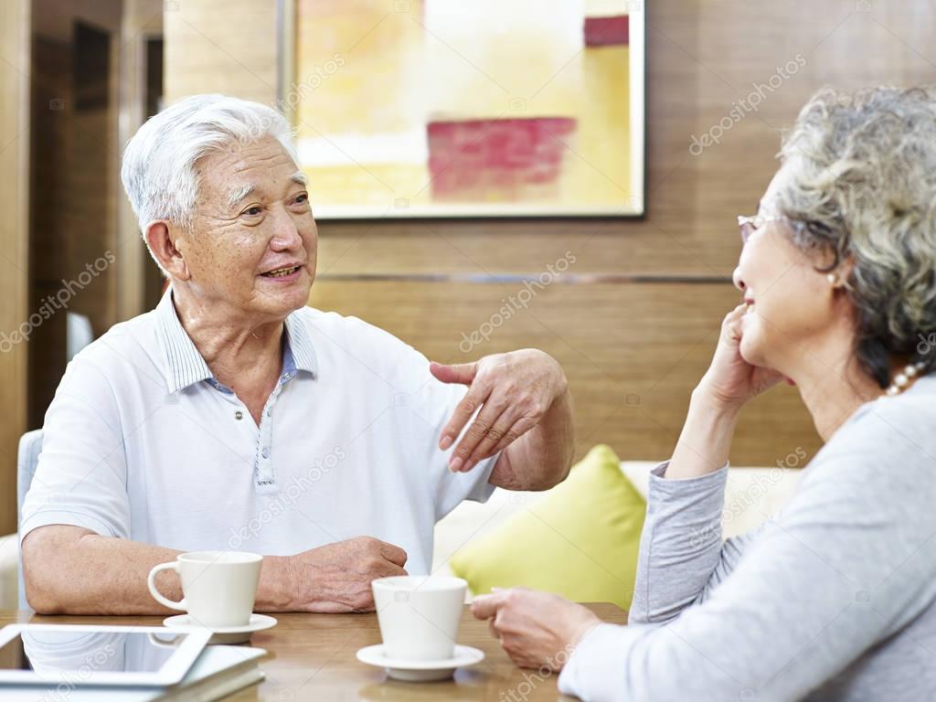 senior asian couple having a conversation at home