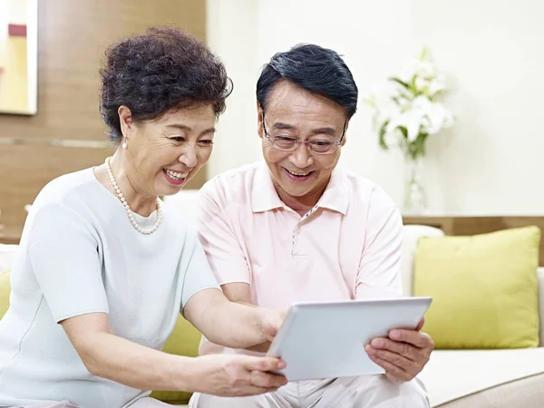 Sênior asiático casal usando tablet computador juntos — Fotografia de Stock