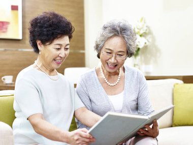 iki üst düzey Asyalı kadınlar birlikte bir kitap okuma