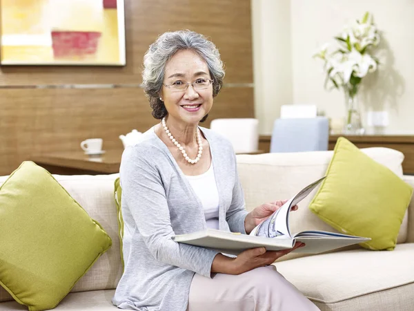 Sênior asiático mulher ler um livro — Fotografia de Stock