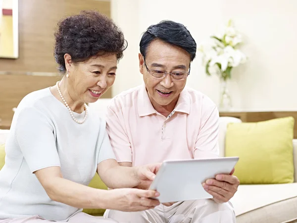 Senior asian couple using tablet computer together — Stock Photo, Image