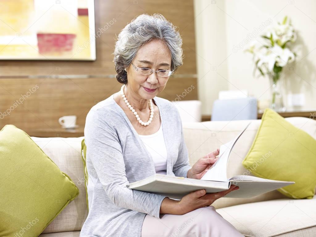 senior asian woman reading a book