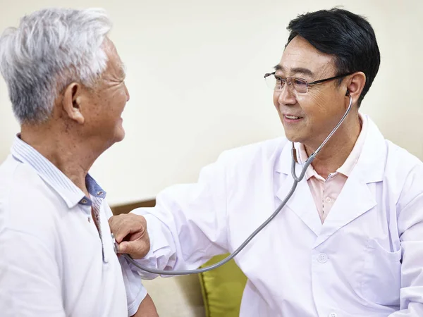 Aziatische arts controleren senior patiënt — Stockfoto