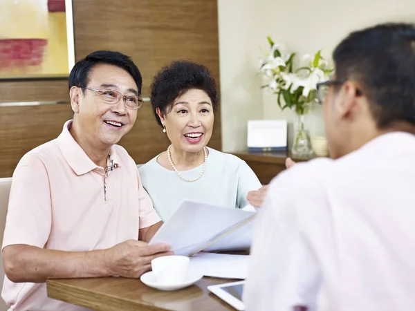 Senior asian couple listening to a salesman — Stock Photo, Image