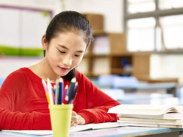 Asian elementary schoolgirl studying in classroom — Stock Photo, Image