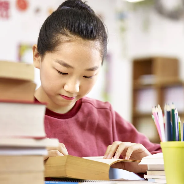 Asiático escuela primaria alumno leyendo un libro en aula — Foto de Stock