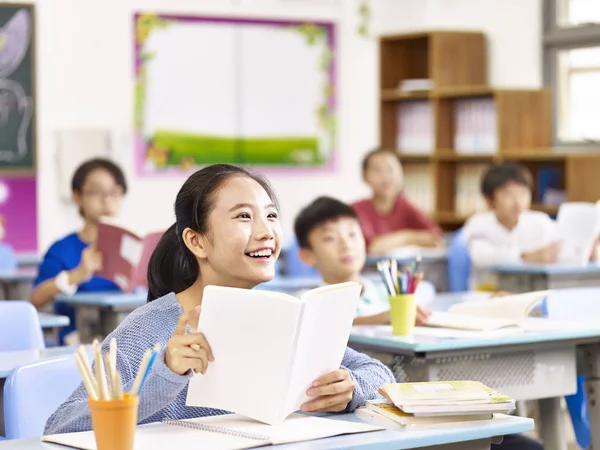 Asiático primaria la escuela chica sonriendo en clase —  Fotos de Stock