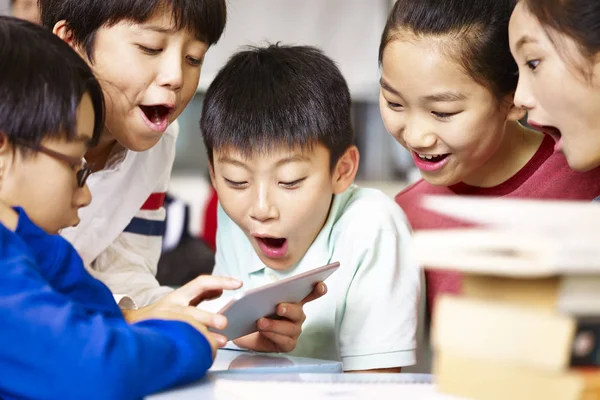 Grupo de asiático escuela primaria alumno jugando juego usando tableta —  Fotos de Stock