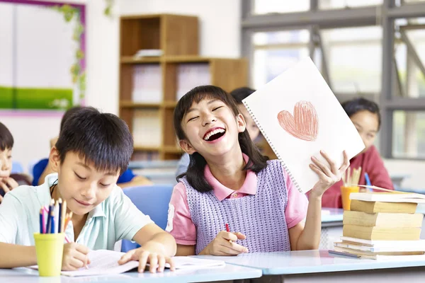 Прекрасная азиатская школьница показывает свой рисунок — стоковое фото