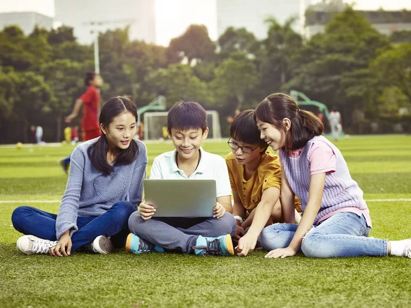 야외에서 노트북을 사용 하 여 아시아 초등학교 어린이 — 스톡 사진
