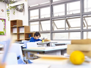 sınıfta okuyan Asyalı okullu çocuk