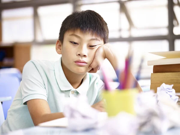 Sorgliga skolbarn sitter ensam i klassrummet — Stockfoto