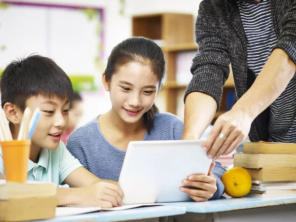 Азиатские младшие школьники используют цифровые планшеты в классе — стоковое фото