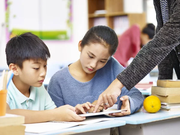 Aziatische elementaire schoolkinderen met behulp van digitale tablet in classroo — Stockfoto