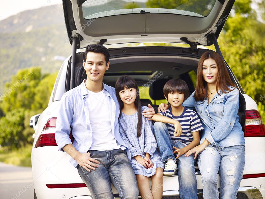 happy asian family traveling by car
