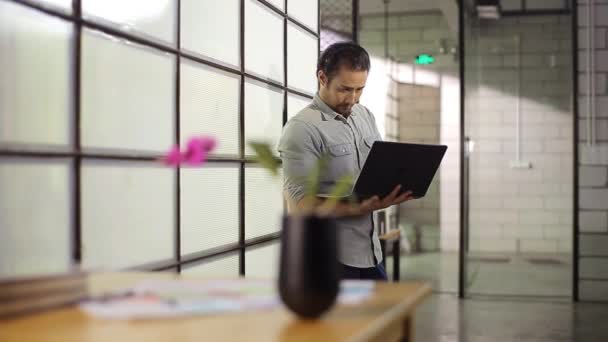 Asiático hombre de negocios holding laptop pensamiento en oficina — Vídeo de stock