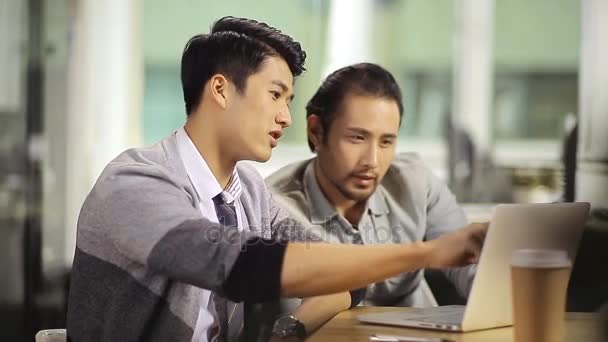 Asiatiska affärsmän som arbetar ihop med laptop — Stockvideo
