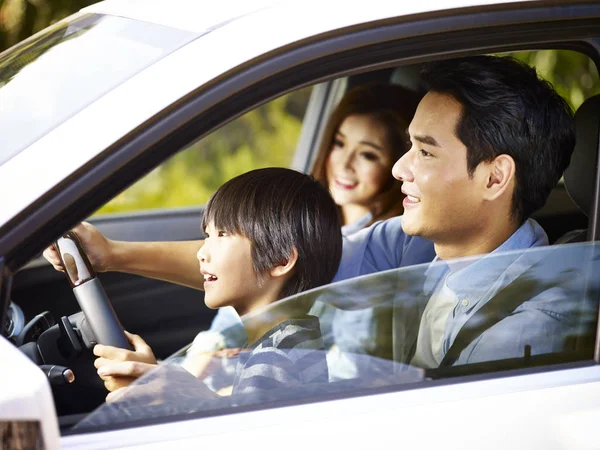 Asian father letting son hold the steering wheel — Stock Photo, Image