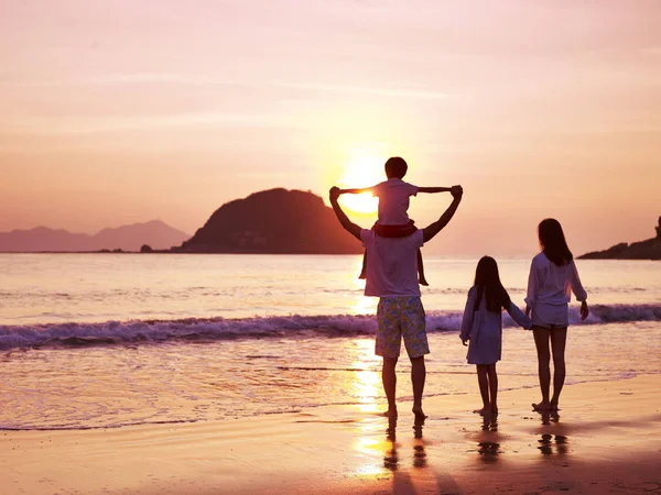 Asiática família assistindo nascer do sol na praia — Fotografia de Stock