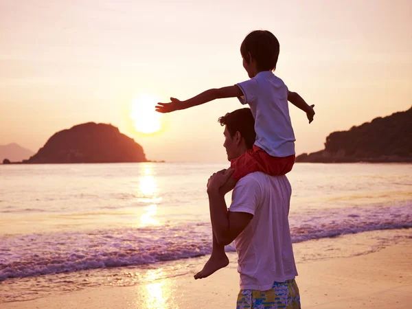 Asian father and son on beach at sunrise — Stock Photo, Image