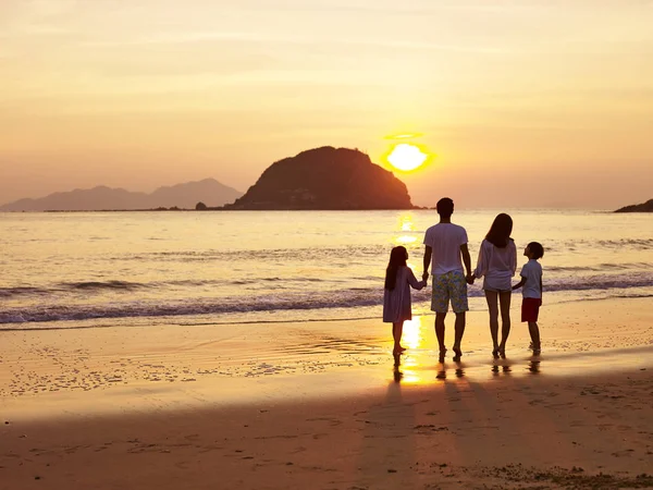 Asian family watching sunrise or sunset on beach — Stock Photo, Image