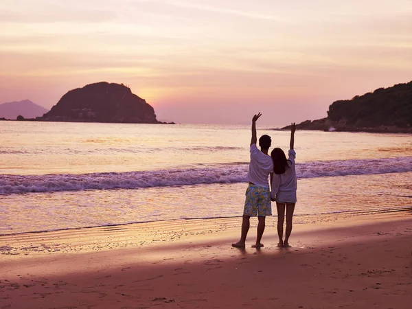 Joven asiático pareja esperando para sunrise en playa — Foto de Stock