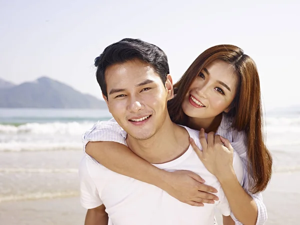 Jovem asiático casal se divertindo na praia — Fotografia de Stock