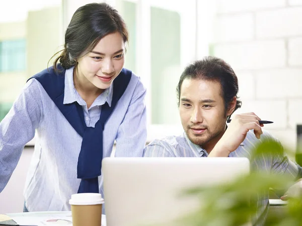 Азиатский бизнесмен и женщина, работающие вместе в офисе — стоковое фото