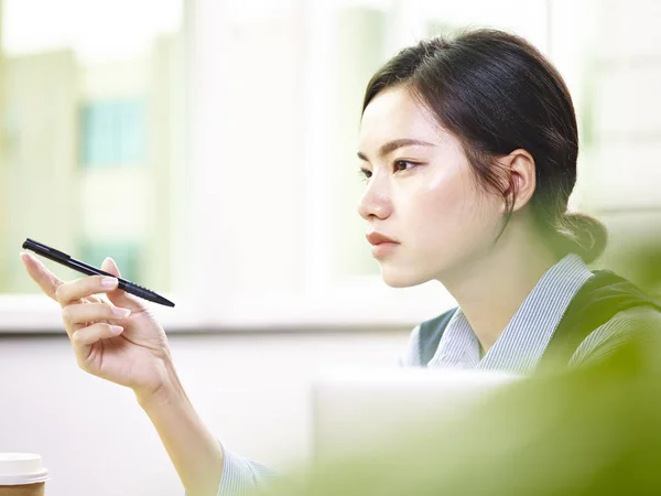 Phone, thinking and man by office window for career inspiration, job search  or online networking. Contemplating asian person or young entrepreneur  cellphone, smartphone or mobile app in workplace Stock Photo