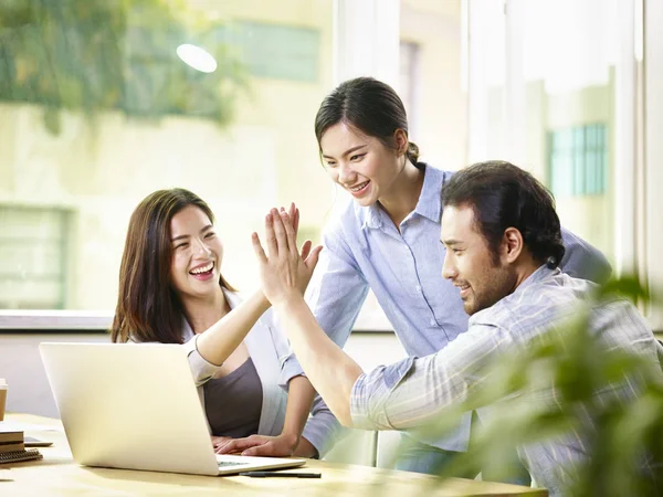Asian business people celebrating success in office — Stock Photo, Image