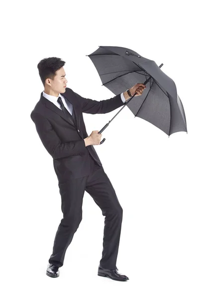 Asiático hombre de negocios aferrándose a un negro paraguas — Foto de Stock