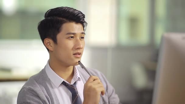 Молодой азиатский бизнесмен, работающий в офисе — стоковое видео