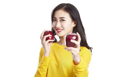 iki elma gösterilen genç Asyalı kadın