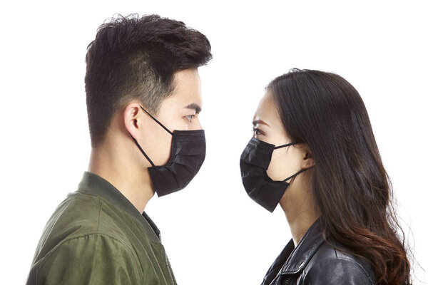 asian couple wearing mask staring at each other