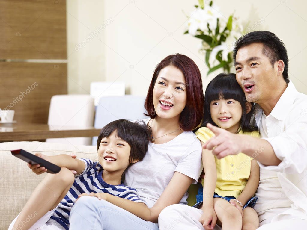 happy asian family watching TV at home