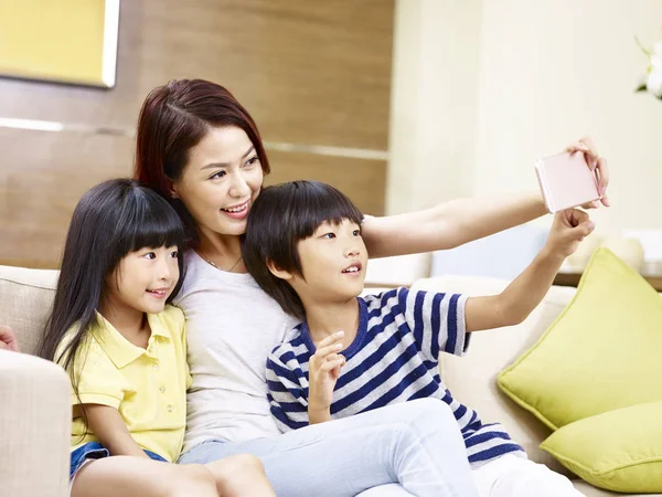 Asian mother and children taking a selfie at home — Stock Photo, Image