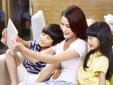 Asya anne ve çocuk evde bir selfie alarak