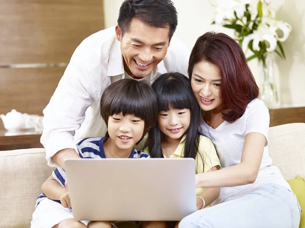 Familia asiática con dos niños usando laptop juntos —  Fotos de Stock