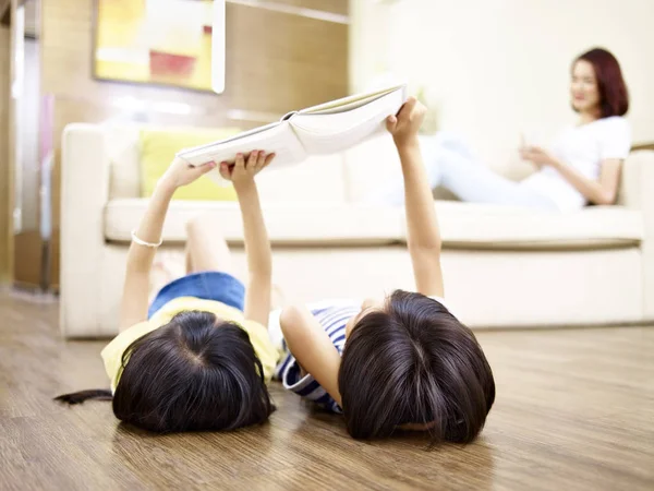 Aziatische broers en zussen op vloer met behulp van digitale tablet liggen — Stockfoto