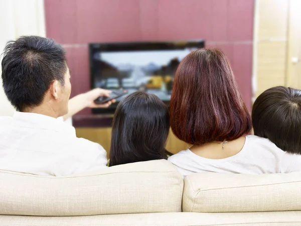 Asiática família com duas crianças assistindo TV juntos — Fotografia de Stock