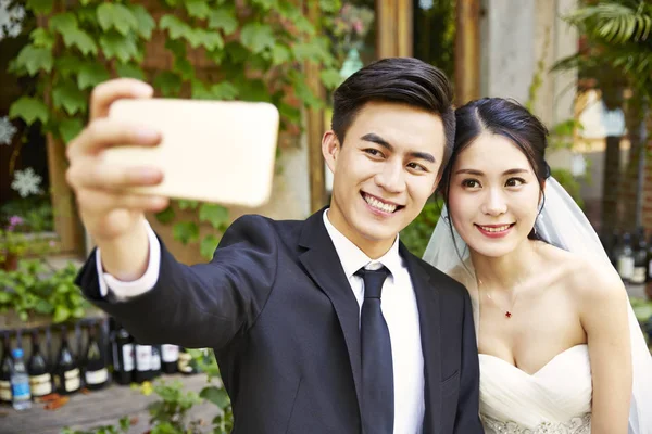 Jovem ásia noiva e noivo tomando um selfie — Fotografia de Stock