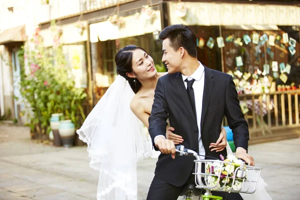 Romântico asiático recém-casado montando uma bicicleta — Fotografia de Stock