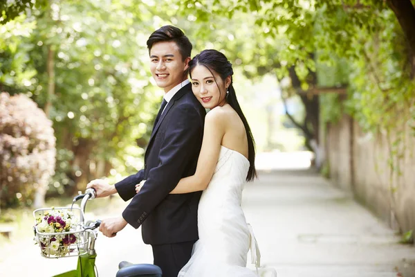 Азиатская свадебная пара на велосипеде — стоковое фото