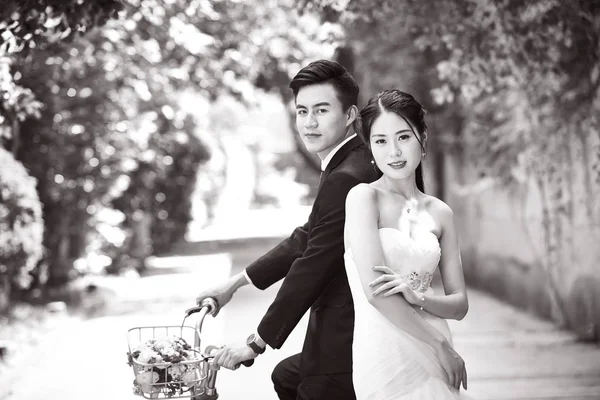 Asian wedding couple riding bicycle — Stock Photo, Image