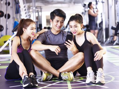 spor salonunda cep telefonu bakarak genç Asya Yetişkin