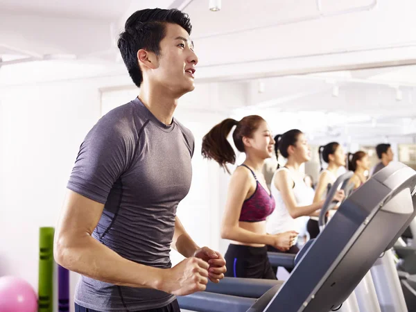 亚洲年轻人在跑步机上锻炼 — 图库照片