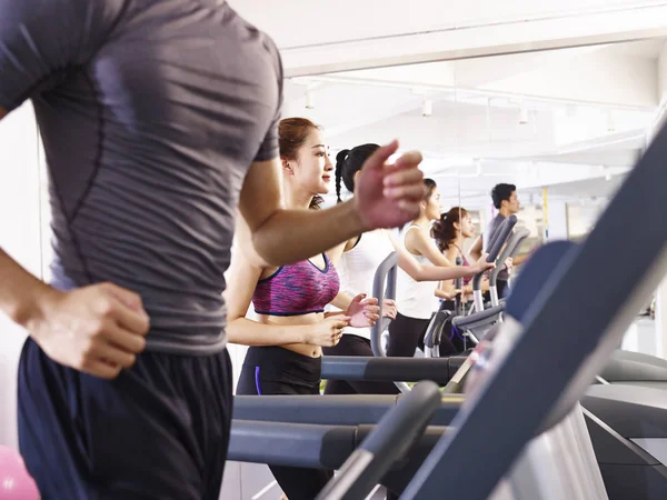 asian young people working out on treadmill