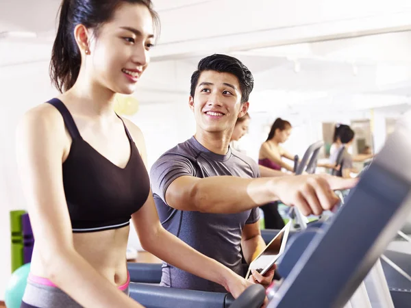 Young asian adults exercising on treadmill — Stock Photo, Image