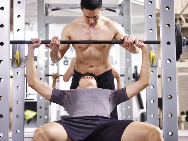 Young asian man lifting weight in gym — Stock Photo, Image