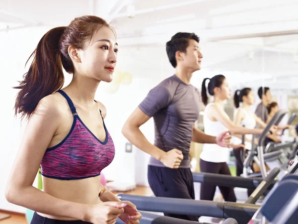 asian young people working out on treadmill